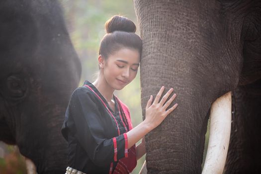 Portrait Of Young Woman Standing By Elephant In Forest