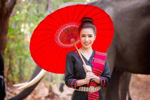 Portrait Of Young Woman Standing By Elephant In Forest