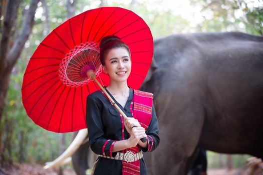 Portrait Of Young Woman Standing By Elephant In Forest