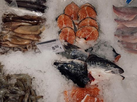 Top view of shop selling fresh raw fish arranged on ice.