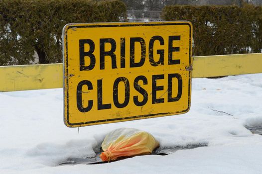 A sign informing traffic that the local bridge is currently closed for safety reasons.