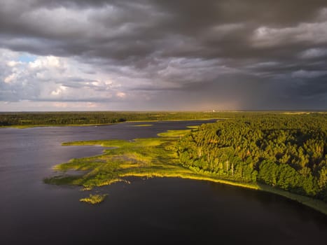 Stromy clouds over eautful peninsula between lakes Snudy and Strusto, National Park Braslau Lakes, Belarus.