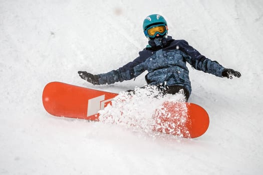 Person go down on a snowboard from the mountainside along a specially prepared track. They make mistakes and fall. Ski vacation. January, Logoisk, Belarus