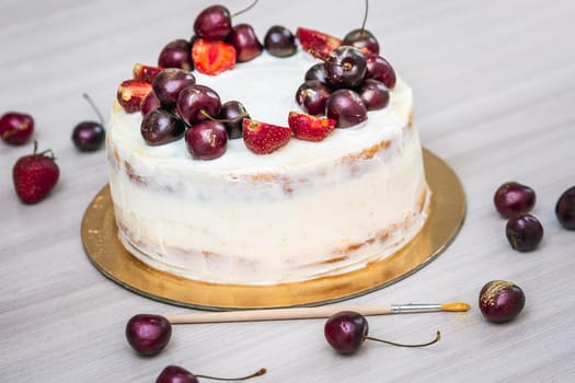 Cherries and strawberries with edible gold on top of cheesecake with coconut.