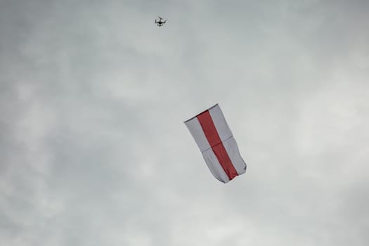 Historic flag of Belarus fly in the sky by the drone.