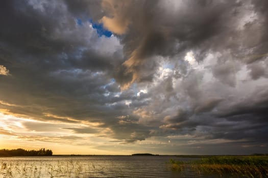 Amazing sunset at the Braslaw lakes with the cloudy sky. Braslaw district, Belarus.