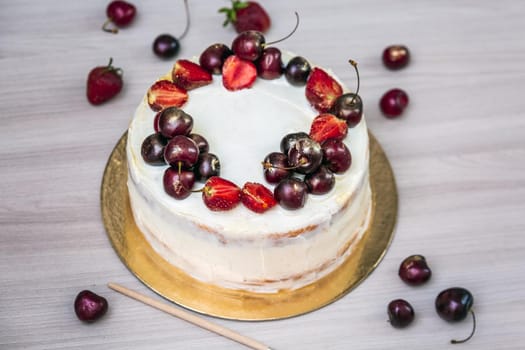 Cherries and strawberries with edible gold on top of cheesecake with coconut.