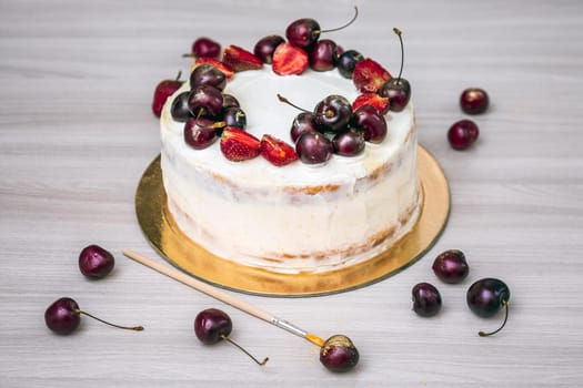 Cherries and strawberries with edible gold on top of cheesecake with coconut.
