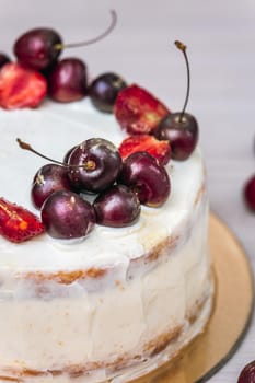 Cherries and strawberries with edible gold on top of cheesecake with coconut.