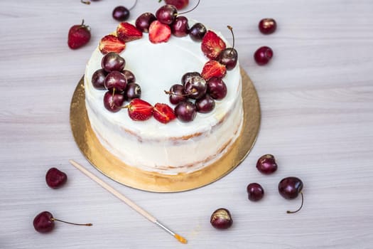 Cherries and strawberries with edible gold on top of cheesecake with coconut.