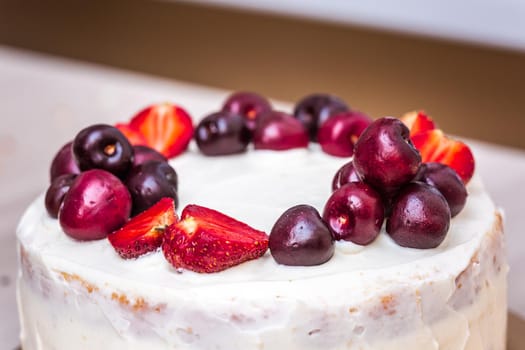 Cherries and strawberries on top of cheesecake with coconut.
