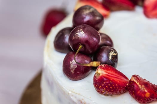 Cherries and strawberries with edible gold on top of cheesecake with coconut.