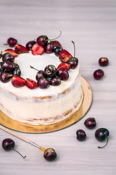 Cherries and strawberries with edible gold on top of cheesecake with coconut.