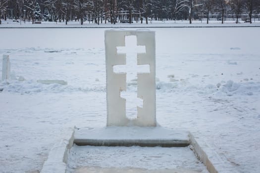 Cross near ice bath. Winter Baptism in Minsk Belarus. Baptismal bathing - a folk tradition that exists in Russia, Belarus, Ukraine. Bathing in the ice hole. Plunge into the ice water.