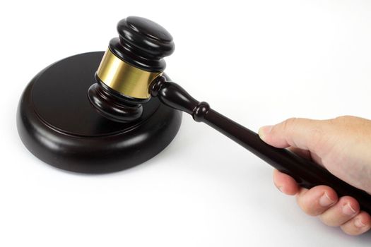 Hand holding a Wooden judge hammer on white background