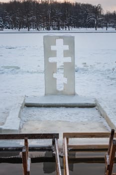 Cross near ice bath. Winter Baptism in Minsk Belarus. Baptismal bathing - a folk tradition that exists in Russia, Belarus, Ukraine. Bathing in the ice hole. Plunge into the ice water.