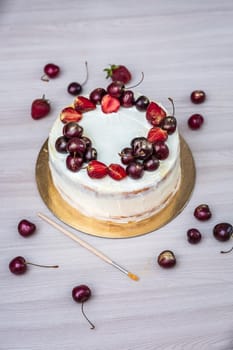 Cherries and strawberries with edible gold on top of cheesecake with coconut.