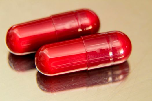 Red capsules on metallic surface background
