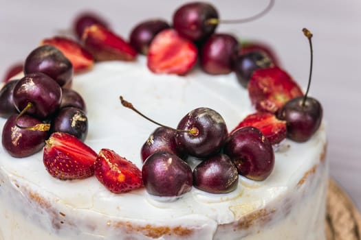 Cherries and strawberries with edible gold on top of cheesecake with coconut.