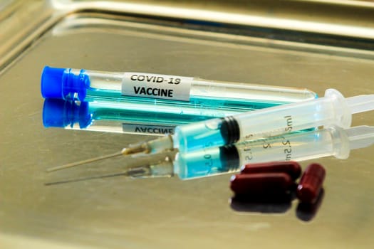 Syringe next to test tube with vaccine for Covid-19 virus
