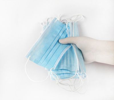 Hand on surgical gloves hanging Disposable Medical masks on white background. Covid-19 and healthcare concept