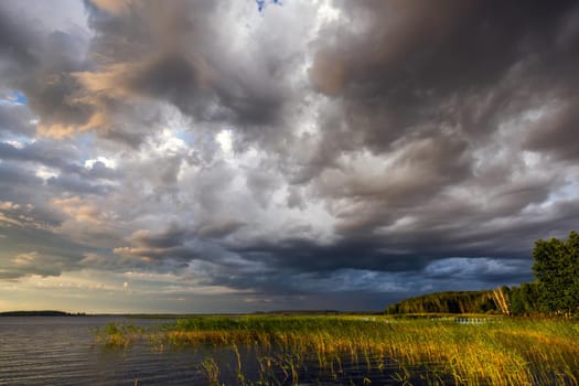 Amazing sunset at the Braslaw lakes with the cloudy sky. Braslaw district, Belarus.