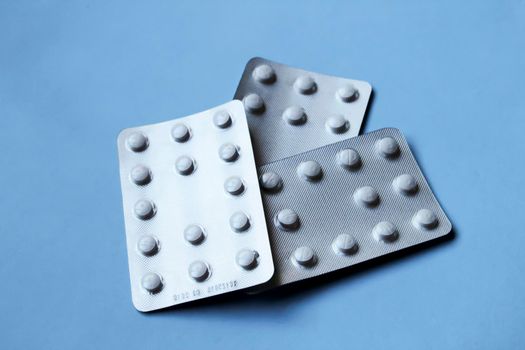 White pill blister packs on blue background
