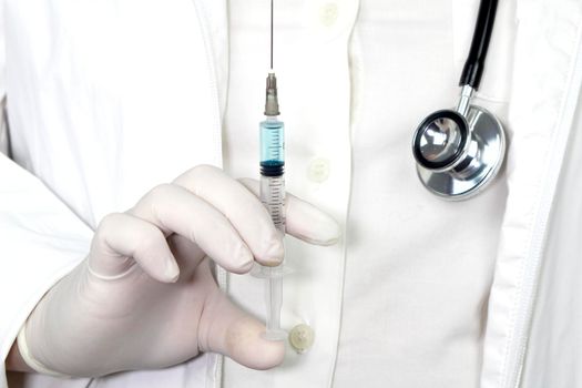 Medical professional on white uniform and surgery gloves holding a syringe with Covid-19 virus vaccine
