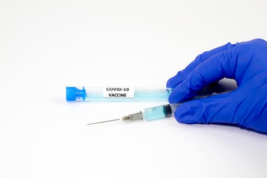 Medical professional hand with surgery glove holding a syringe with Covid-19 virus vaccine