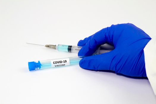 Medical professional hand with surgery glove holding a syringe with Covid-19 virus vaccine