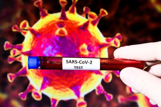 Hand holding test tube with blood sample for Covid-19 virus test and microscopic image of covid virus in the background. 