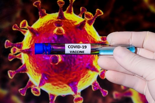 Medical professional hand with surgery glove holding Covid-19 virus vaccine and covid virus microscopic image in the background