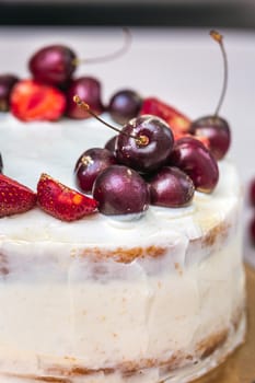 Cherries and strawberries with edible gold on top of cheesecake with coconut.