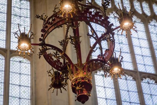 Close-up of a metal chandelier inside a gothic cathedral on a sunny day