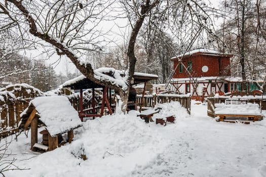 Decorated wooden house with textured wall covered with a heavy snow in the village in Belarus.