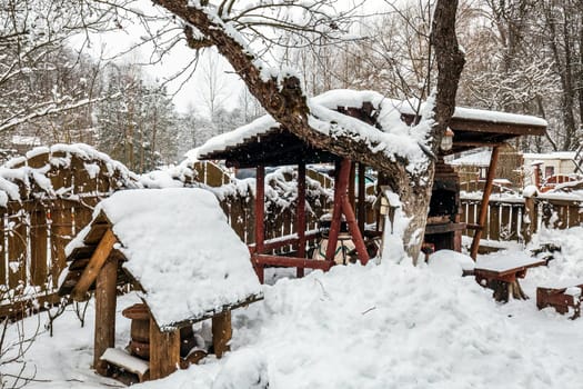 Decorated wooden house with textured wall covered with a heavy snow in the village in Belarus.