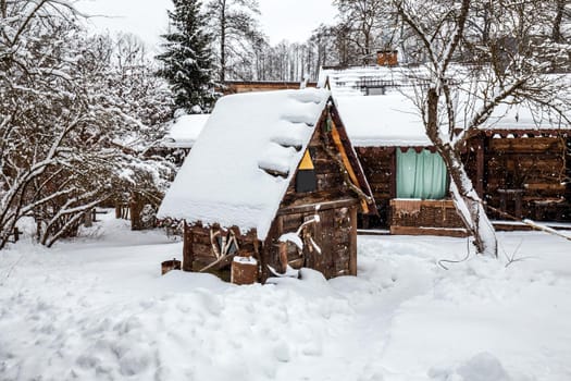 Decorated wooden house with textured wall covered with a heavy snow in the village in Belarus.