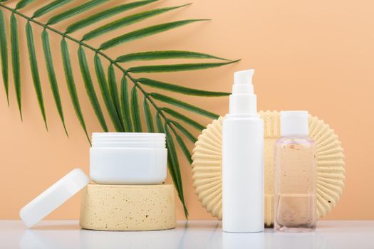 Cosmetic set with mask, cream and lotion against beige background with palm leaf. Concept of organic cosmetics with natural ingredients and oil for daily or anti aging skin care