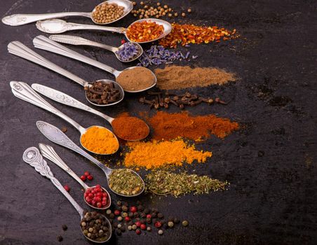 Spices and condiments for cooking on a black background.