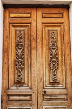 Old colorful carved wooden door in a small village in Castilla La Mancha community, Spain