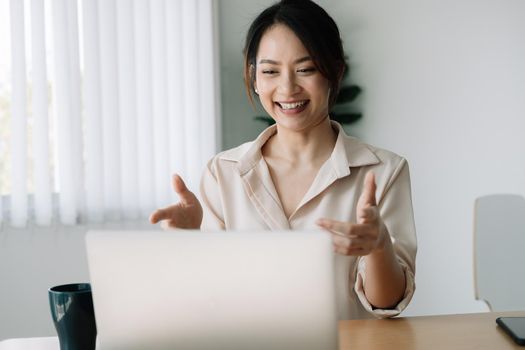 Asian woman watching webinar on laptop computer express opinion offer solution at virtual meeting. Student use pc and internet e-learning remotely