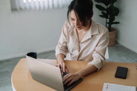 Young businesswoman sitting front open portable laptop computer reading email from client, long hours of work concept