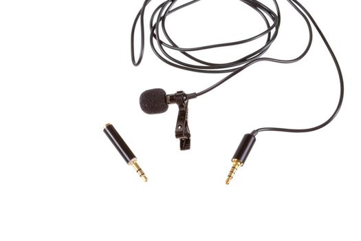 Small lavalier microphone or lapel mic with clip and adapter for computer on white background. Professional sound recording equipment for cell phone.