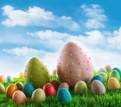 Decorated eggs in the grass with sky in background