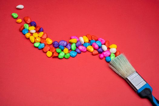 a brush leaves a trail of colored pebbles