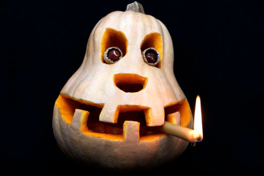 All Saints' Day. Pumpkin. Pumpkin with a candle in his teeth on a black background.