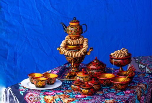 On the table on a colorful tablecloth is a traditional Russian samovar. Russian national tea ceremony.