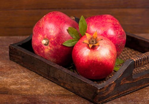 Ripe pomegranate fruits on the wooden background. Top view.