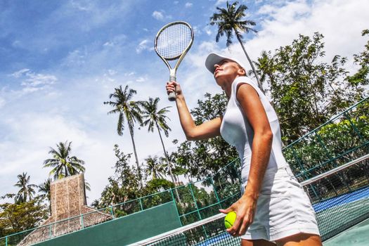 Female tennis player with racket ready to serve a tennis ball