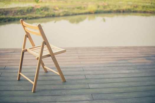wooden chair on balcony terrace patio for resting near pond
